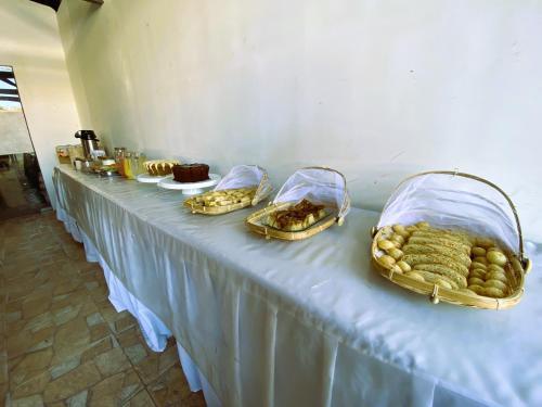 a long table with several baskets of food on it at Pousada Hippopotamus Jeri in Jericoacoara