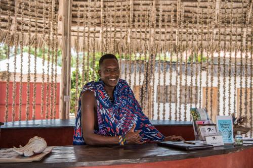 a man sitting at a table in a restaurant at Kupaga Villas Boutique Hotel - Adults Only in Jambiani