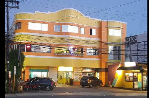 a building with cars parked in front of it at Corazon Tourist Inn in Puerto Princesa City