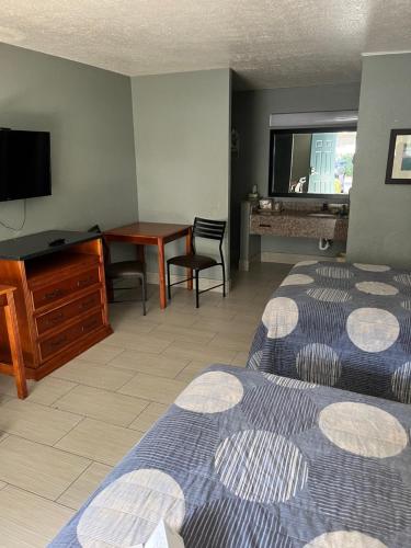 a hotel room with two beds and a desk and a television at Brandon Motor Lodge in Brandon
