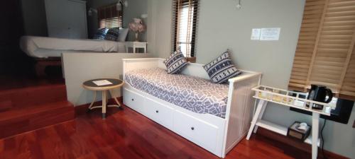 a small bedroom with a bed and a small stool at The Height Khaoyai Resort in Ban Huai Sok Noi