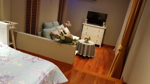 a bedroom with a bed and a chair and a television at The Height Khaoyai Resort in Ban Huai Sok Noi