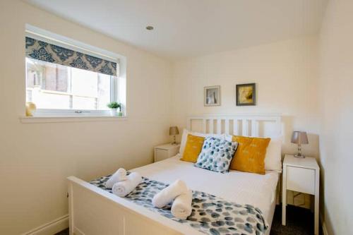 a bedroom with a bed with pillows and a window at South Barlogan Farm in Bridge of Weir