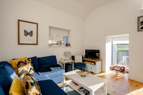 a living room with a blue couch and a table at South Barlogan Farm in Bridge of Weir