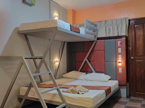 a bedroom with two bunk beds in a room at Corazon Tourist Inn in Puerto Princesa City