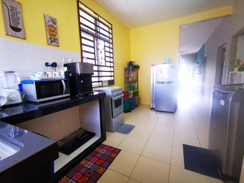 a kitchen with a microwave and a refrigerator at BR Guesthouse Kuantan in Kuantan