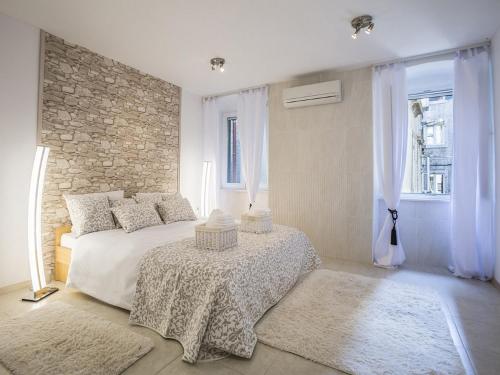 a bedroom with a bed with a table and windows at Iron Gates Apartments in Split