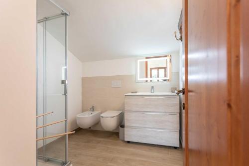bagno con lavandino, servizi igienici e specchio di Villa Pompea int. n ro 3 a Casarano
