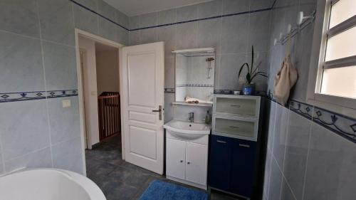 ein Badezimmer mit einem weißen Waschbecken und einem WC in der Unterkunft VILLA CAP détente et SPA in Saint-Louis