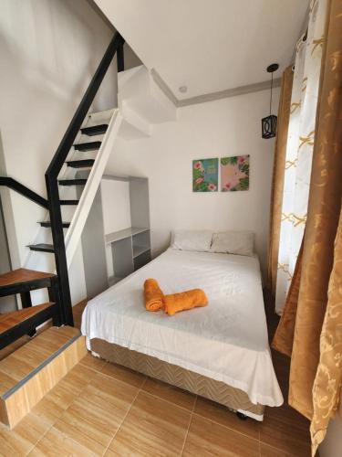 邦勞的住宿－Mannah Garden Staycation Place，一间卧室配有一张带橙色枕头的床