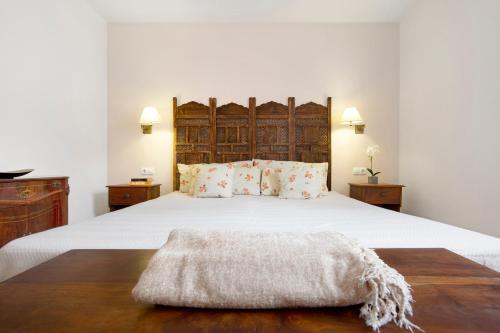 sypialnia z dużym białym łóżkiem z drewnianym zagłówkiem w obiekcie Oasis Tamarindo sport e relax w Corralejo