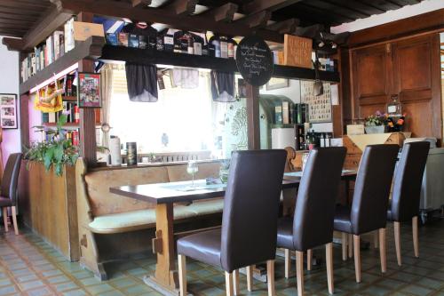 een restaurant met een houten tafel en stoelen bij Landgasthof-Porta in Üllershausen