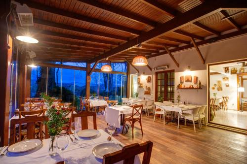 a restaurant with tables and chairs and a large window at Beta Home Lake House Sapanca in Sapanca