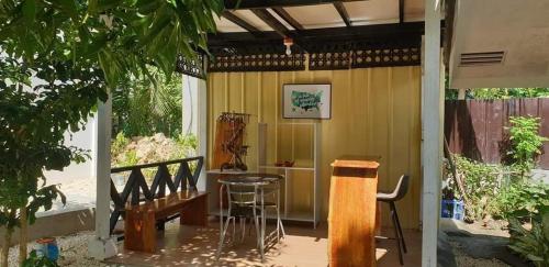 邦勞的住宿－Mannah Garden Staycation Place，门廊配有桌子、椅子和桌子