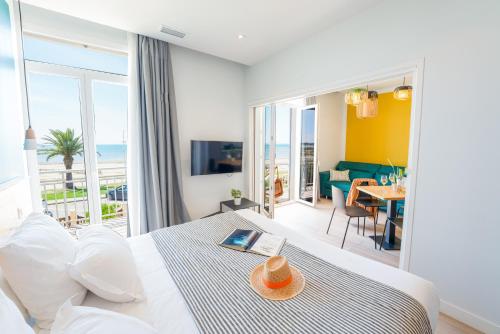 a bedroom with a bed with a view of the ocean at Hôtel Café Miramar in Le Grau-du-Roi