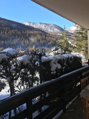 a view of a snow covered mountain from a balcony at Ambiance petit chalet in La Salle-les-Alpes