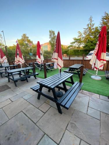 a group of picnic tables with umbrellas on a lawn at The Redwell Inn in Barnard Castle