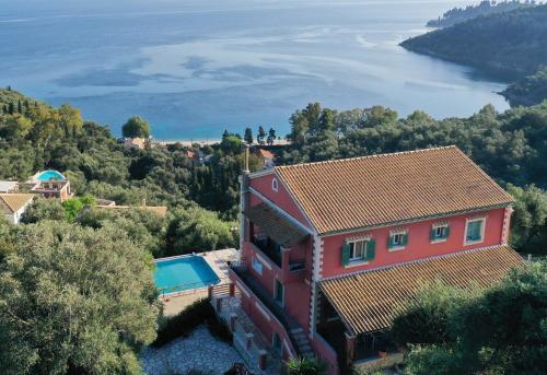 an aerial view of a red house and the water at Villa Vasso Sea View Residences in Agnítsini