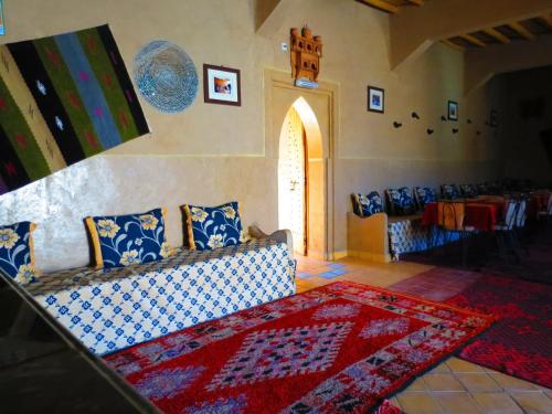 a living room with a couch and a table at Hôtel Riad Tadarte Familier in Merzouga