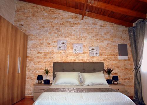 Un dormitorio con una pared de ladrillo y una cama en Harmony, en Lávrion