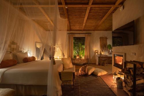 a bedroom with a bed and a living room with a fireplace at Salvaterra Country House & SPA in Salvaterra de Magos