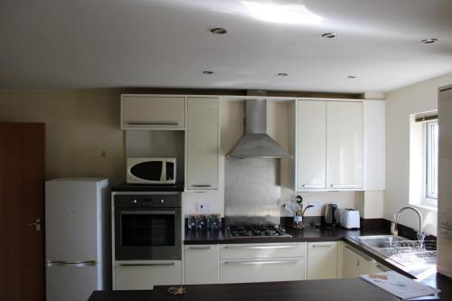 a kitchen with white cabinets and a stove top oven at Two Bedroom Apartment, Free parking, Close to UCLAN and free WIFI in Preston