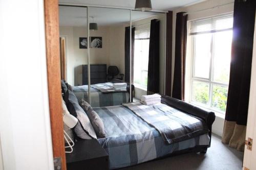 - une chambre avec un lit et un grand miroir dans l'établissement Two Bedroom Apartment, Free parking, Close to UCLAN and free WIFI, à Preston