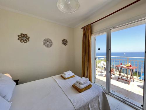 een slaapkamer met een bed en uitzicht op de oceaan bij Villa Seagull in Skála Kefalonias