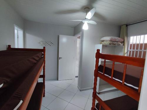 a bedroom with a bed and a ceiling fan at APARTAMENTO ESTRELA DO MAR A 1 QUADRA DO MAR in Guaratuba