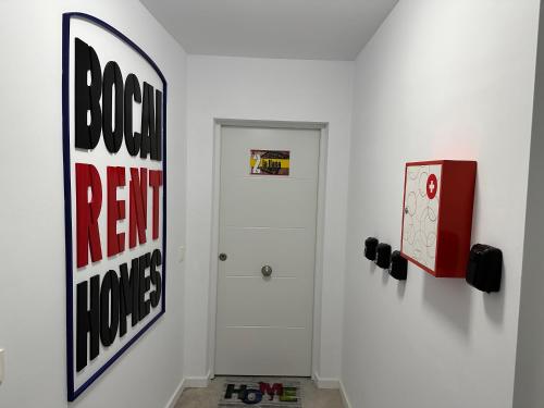 a hallway with a white door and a sign on the wall at Apartamentos BocairentHomes, en pleno centro de Bocairent, con pequeña piscina y parking privado in Bocairent