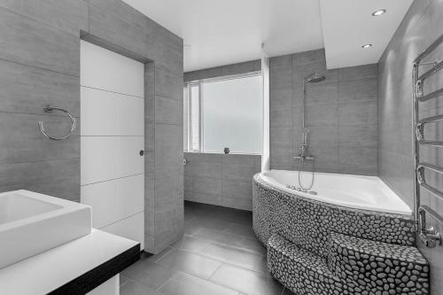 een badkamer met een bad en een wastafel bij Central Reykjavík Apartment in Reykjavík