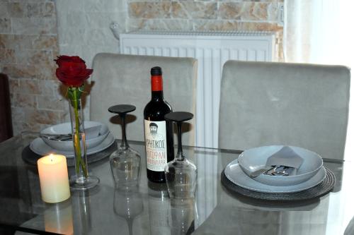 a glass table with two bottles of wine and a candle at Harmony in Lávrion