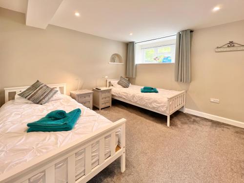 Un dormitorio con dos camas y una ventana. en 1 Dolphin Court, Brixham, en Brixham