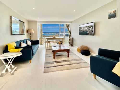 a living room with a blue couch and a table at 1 Dolphin Court, Brixham in Brixham