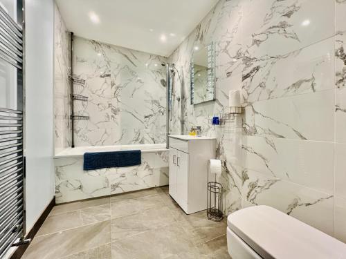 a white bathroom with a toilet and a sink at 1 Dolphin Court, Brixham in Brixham