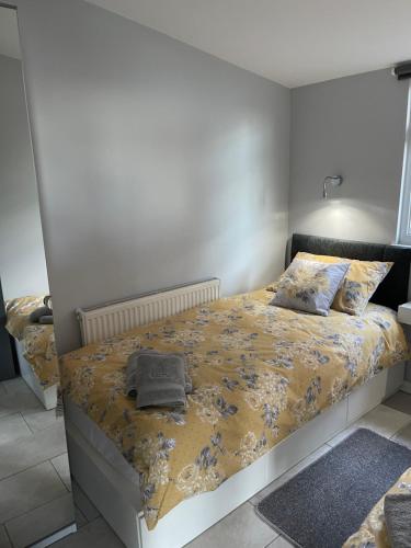 a bedroom with a bed with a yellow comforter at Eden Garden in Llangain