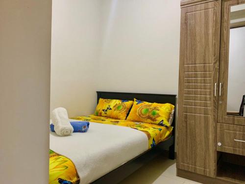 a bedroom with a bed with yellow sheets and yellow pillows at Sea Residences, S, Shell Janine's Residency in Manila