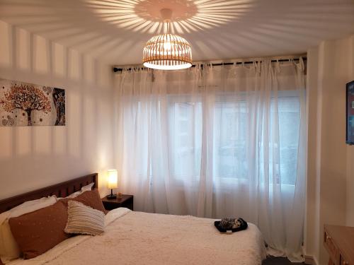 Schlafzimmer mit einem Bett und einem Kronleuchter in der Unterkunft Maison du Bonheur 2 à TROYES Logement entier avec parking in Troyes
