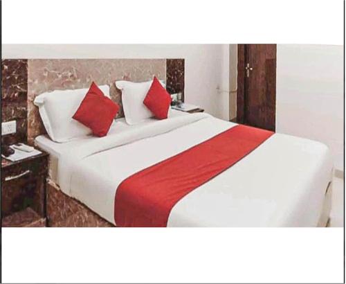 a bedroom with a large bed with red and white pillows at Hotel Blue Palace By WB Inn in New Delhi