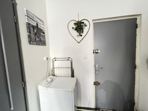 - une salle de bains avec un lave-linge et un sèche-linge à côté d'une porte dans l'établissement La Cachette de l'Horloge - AC CLIM - WIFI - 100m PALAIS DES PAPES, à Avignon