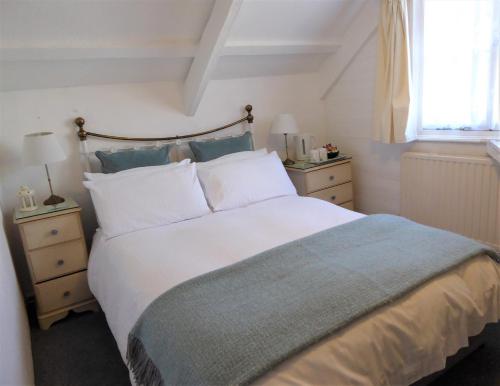 - une chambre avec un grand lit blanc et une fenêtre dans l'établissement Grey Mullet Guest House, à St Ives