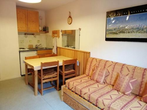 a living room with a couch and a table and a kitchen at Studio cosy au pied des pistes avec balcon, 3 couchages - FR-1-557-58 in Les Adrets
