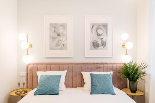 a bedroom with a bed with blue pillows at Crystal House II - LoftAffair Collection in Kraków