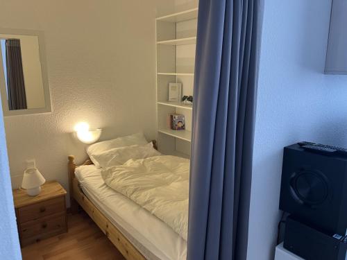 - une petite chambre avec un lit et un rideau bleu dans l'établissement Hahnenklee Waldblick Cari, à Hahnenklee