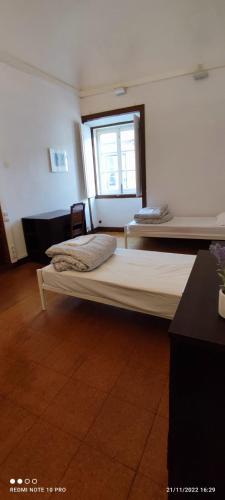 a room with two beds and a window at Hostel Raymundo in Évora