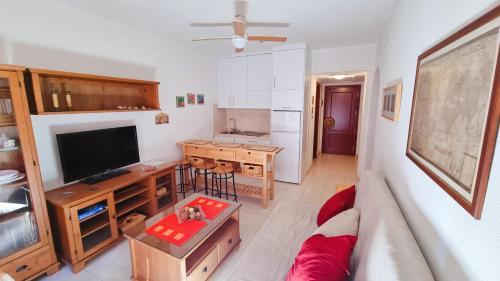 a living room with a couch and a flat screen tv at Apartamento rojo con vistas al mar in Mazagón