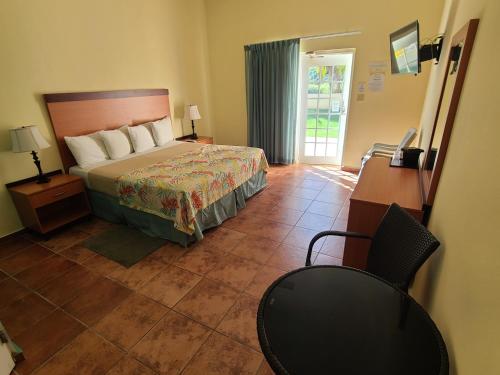 1 dormitorio con cama, escritorio y silla en Hotel Lucía Beach en Yabucoa