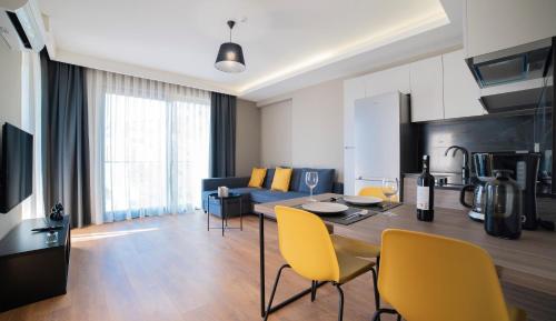 a living room with a table and yellow chairs at Vesta Rooms in Antalya