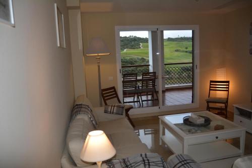 een woonkamer met een bank en een tafel bij Nueva Alcaidesa 2104 - Sea Sun and Green in San Roque