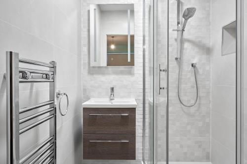 a bathroom with a shower and a sink and a mirror at Luxury Apartment near O'Connell Street in Dublin